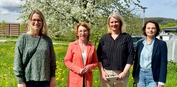Vier Frauen stehen auf dem Gelände des Campus Remagen der Hochschule Koblenz vor einem blühenden Baum